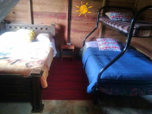 a bedroom with two beds and a sun on the wall at Cabaña vista hermosa Matazanos in San Ramón Sur