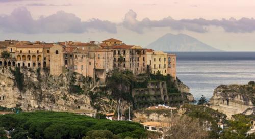 a building on the side of a mountain next to the water at Villetta da Salvo 10 minuti da Capo Vaticano in Coccorino