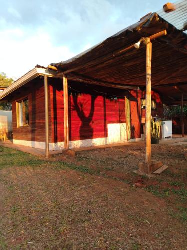 a house with a roof with a red wall at Cabaña vista hermosa Matazanos in San Ramón Sur
