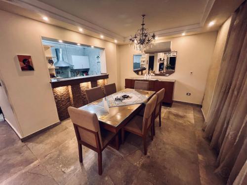 a dining room with a table and chairs and a kitchen at Hidden Gem Few Steps from the Airport in Cairo