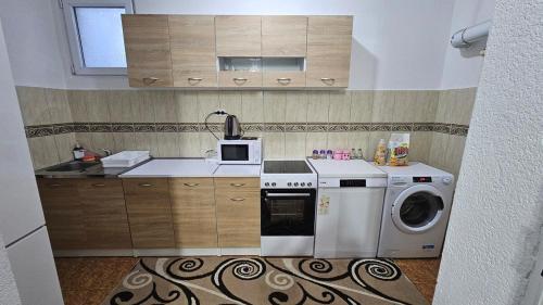 a kitchen with a washing machine and a microwave at Guest house Boljević in Rap