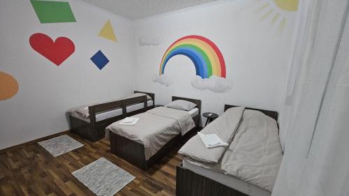 a room with two beds and a rainbow on the wall at Guest house Boljević in Rap
