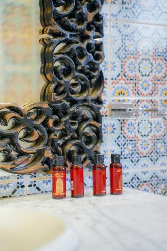 a group of four bottles of sauce next to a wall at RIAD REDWAN in Marrakech