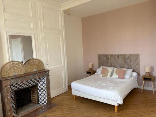 a bedroom with a bed and a fireplace at Le Manoir de Conteville in Paluel