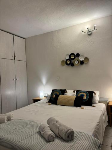 a bedroom with two beds and a clock on the wall at Cozy apartment by Athens in Athens
