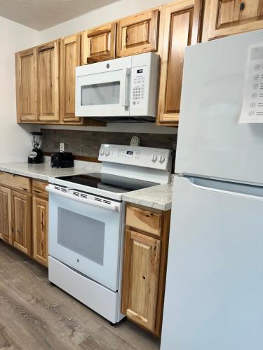 a kitchen with white appliances and wooden cabinets at 1 mi to Dollywood mins to all attractions & GSMNP in Sevierville