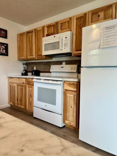 a kitchen with white appliances and wooden cabinets at 1 mi to Dollywood mins to all attractions & GSMNP in Sevierville