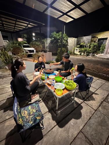 a group of people sitting around a table eating food at Villa FiFa in Blimbing