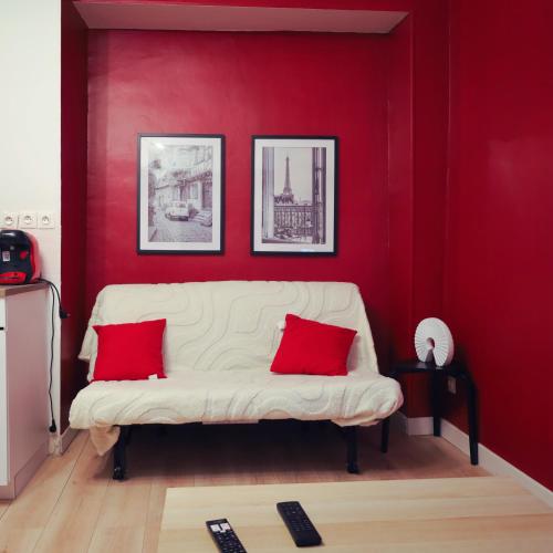 - un salon rouge avec un canapé blanc et des oreillers rouges dans l'établissement Château Rubis T2 hypercentre historique au pied du château, à Château-Thierry