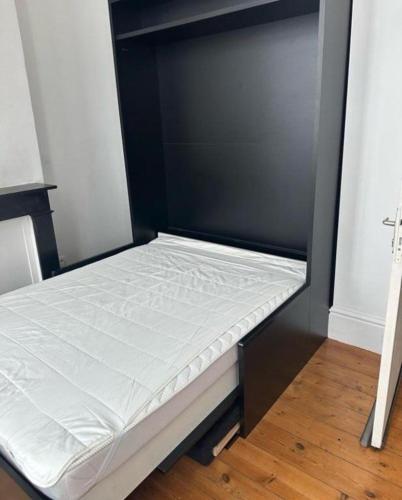Ce lit se trouve dans un dortoir doté d'un mur noir. dans l'établissement COUP DE COEUR Bon Plan Chambre 3 pers located history GRAND PLACE DE LILLE, à Lille