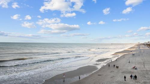 a group of people walking on the beach at Capers Blade - Across From Beach - Garage in Myrtle Beach