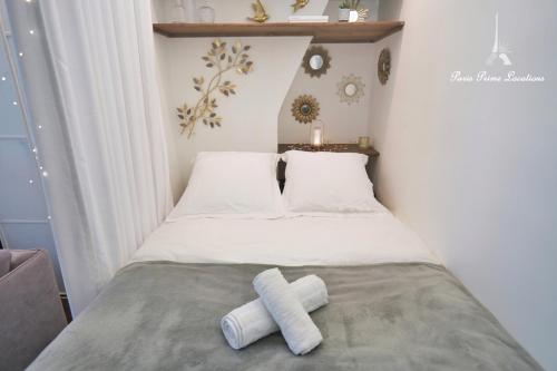 - une petite chambre avec un lit et 2 serviettes dans l'établissement L'appartement du duc de Choiseul - Coeur Opéra, à Paris