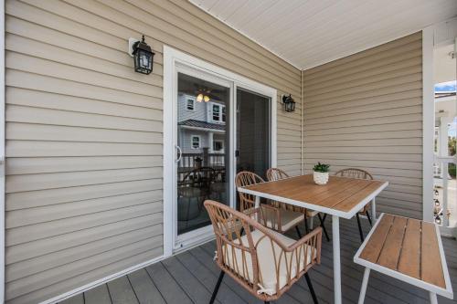 a patio with a table and chairs on a porch at Capers Blade - Across From Beach - Garage in Myrtle Beach
