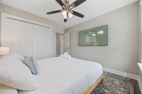 a bedroom with a white bed and a ceiling fan at Capers Blade - Across From Beach - Garage in Myrtle Beach