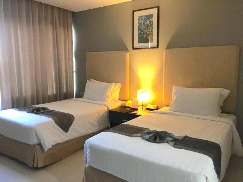 a hotel room with two beds with bows on them at The Patra Hotel - Rama 9 in Bangkok