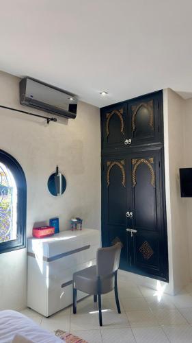a bathroom with a sink and a chair and a door at RIAD REDWAN in Marrakech