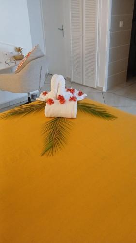 a towel sitting on top of a yellow bed at Au Nid de KLOE, proche plage privée in Grand-Bourg