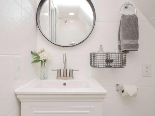a bathroom with a white sink and a mirror at Jennifer's Cozy Tower Lookout 3BR Brown U Views in Providence