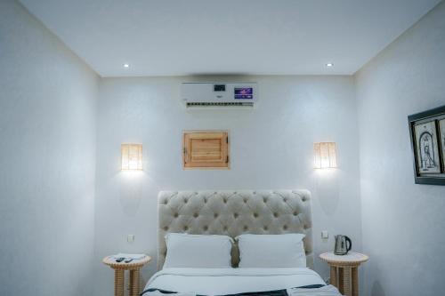 a white room with a bed and two tables at RIAD REDWAN in Marrakech