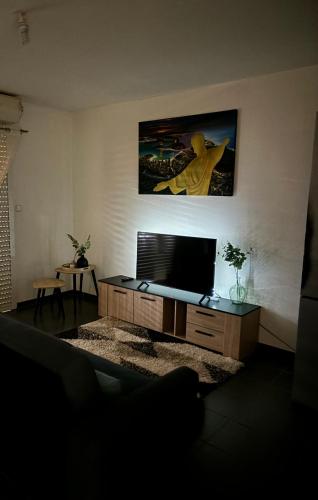a living room with a flat screen tv on a table at T2 - Cayenne spacious center in Cayenne