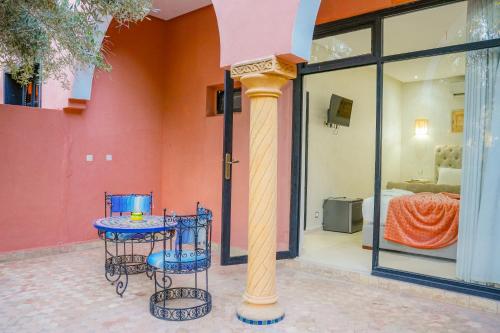 a table and two chairs in front of a room at RIAD REDWAN in Marrakech