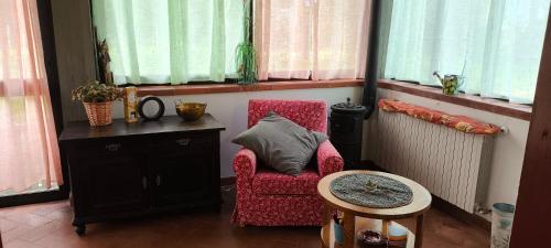 a room with a chair and a table and windows at Artenatura BeB in Terranuova Bracciolini