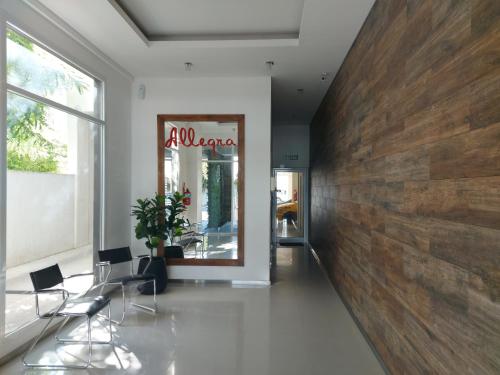 a lobby with a wooden wall and two chairs at Departamento Céntrico in Puerto Madryn