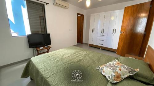 a bedroom with a bed and a flat screen tv at Apto no centro de Torres | Aceita Pet in Torres
