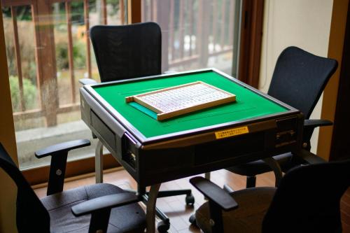 a keyboard sitting on top of a desk with chairs at Hakone Ninotaira Cottage in Onsensō