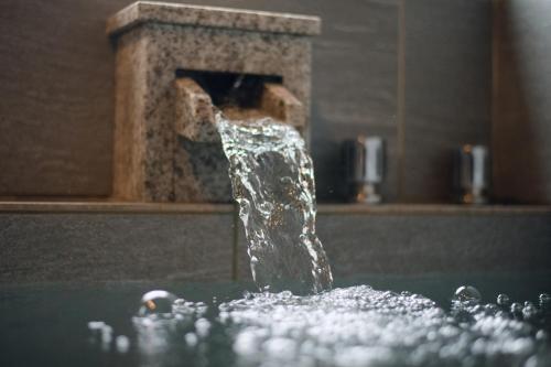 einem Brunnen in der Mitte einer Badewanne in der Unterkunft Hakone Ninotaira Cottage in Onsensō