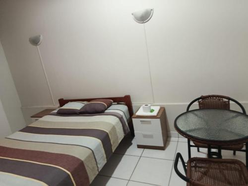two beds in a room with a table and a chair at Hospedaje Cielo Marino in Zorritos