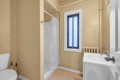 a bathroom with a toilet and a sink and a shower at Cozy Room with Private Bath in Brownstown in Woodhaven