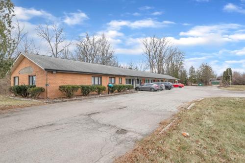 a building with cars parked in a parking lot at Cozy 1BR Retreat in Brownstown – Relax Unwind in Woodhaven