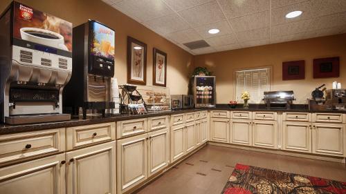 a large kitchen with white cabinets and appliances at Best Western Plus Brandywine Inn & Suites in Monticello