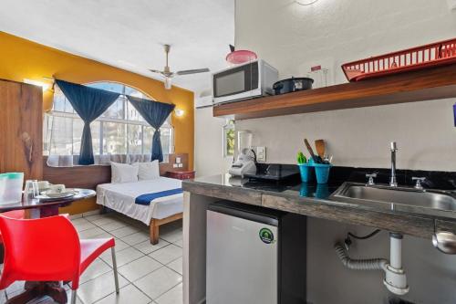 eine Küche mit einem Waschbecken und ein Schlafzimmer mit einem Bett in der Unterkunft Bungalows Yeah Los Ayala in Los Ayala