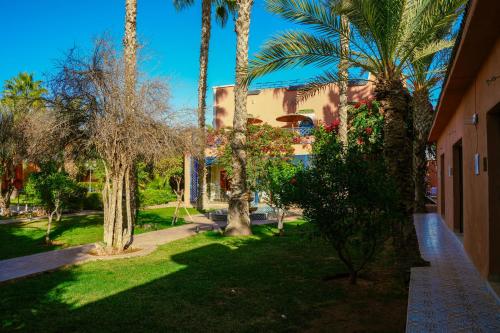 a yard with palm trees and a building at RIAD REDWAN in Marrakech