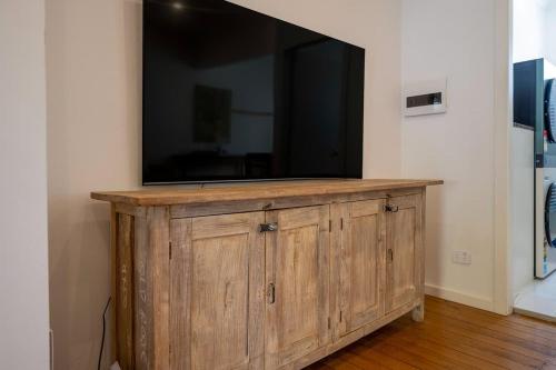 a large television on top of a wooden cabinet at Luxury Couples Stay Bangalow l Nova Escapes in Bangalow