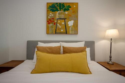 a bedroom with a bed with a yellow pillow at Luxury Couples Stay Bangalow l Nova Escapes in Bangalow
