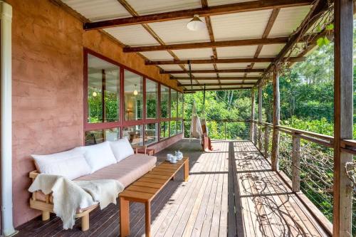 a porch with a couch on a wooden deck at Family-Friendly Hinterland Stay l Nova Escapes in Dorroughby