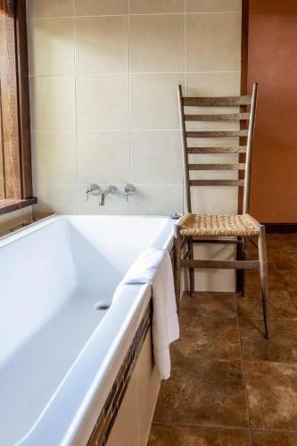 a chair and a bath tub in a bathroom at Family-Friendly Hinterland Stay l Nova Escapes in Dorroughby