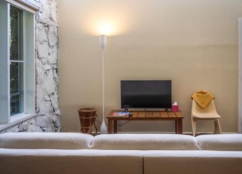 a living room with a couch and a table with a television at Family-Friendly Hinterland Stay l Nova Escapes in Dorroughby