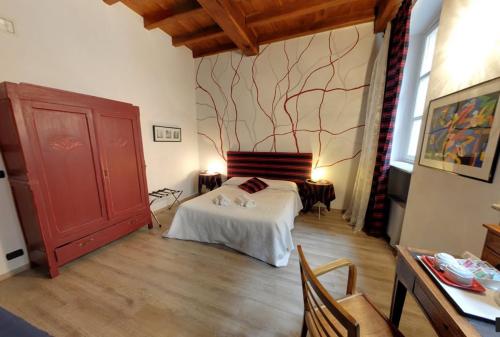 ein Schlafzimmer mit einem Bett und einem Baumbild an der Wand in der Unterkunft Domus Aurea in Saluzzo