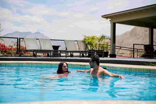 a man and a woman in a swimming pool at Empedrada Ranch & Lodge - Hotel Asociado Casa Andina in Caral