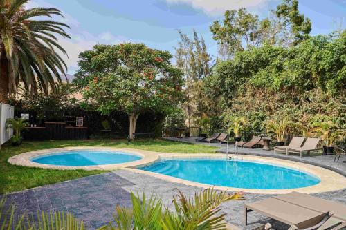 a swimming pool in a yard with chairs and trees at Empedrada Ranch & Lodge - Hotel Asociado Casa Andina in Caral