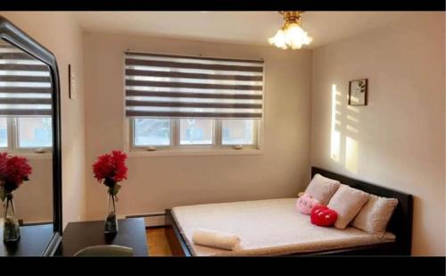 a bedroom with a bed with two red stuffed animals on it at Private bedroom in Montréal