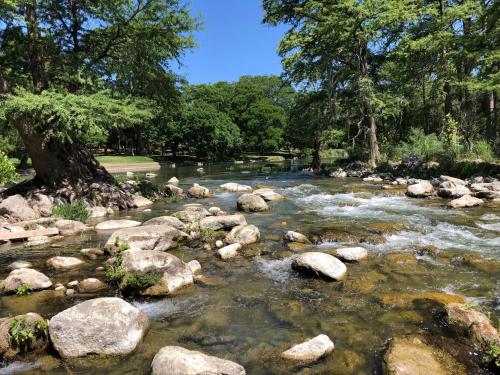 a river with rocks and trees in a park at Hip Gruene Condo, Walk to Gruene Hall, On River! in New Braunfels