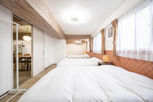 a bedroom with two beds and a dining room at Vacation Inn Omorikaigan 1 in Tokyo