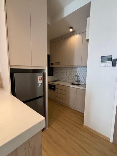 a kitchen with white cabinets and a stainless steel refrigerator at Comfy Stay Near Aman Central with Infinity Pool G Residence in Alor Setar