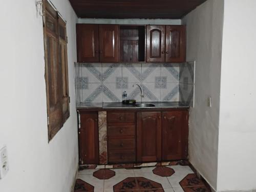 una cucina con armadi in legno e pavimento piastrellato di Paracasa ad Ananindeua