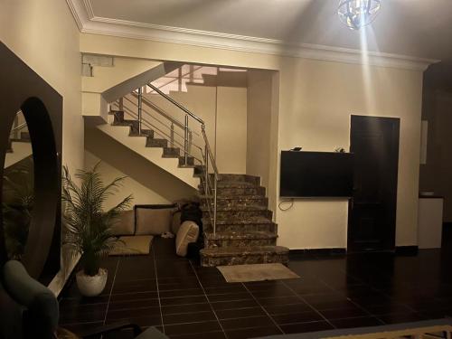 ein Wohnzimmer mit einer Treppe und einem TV in der Unterkunft Relax Home in Kairo